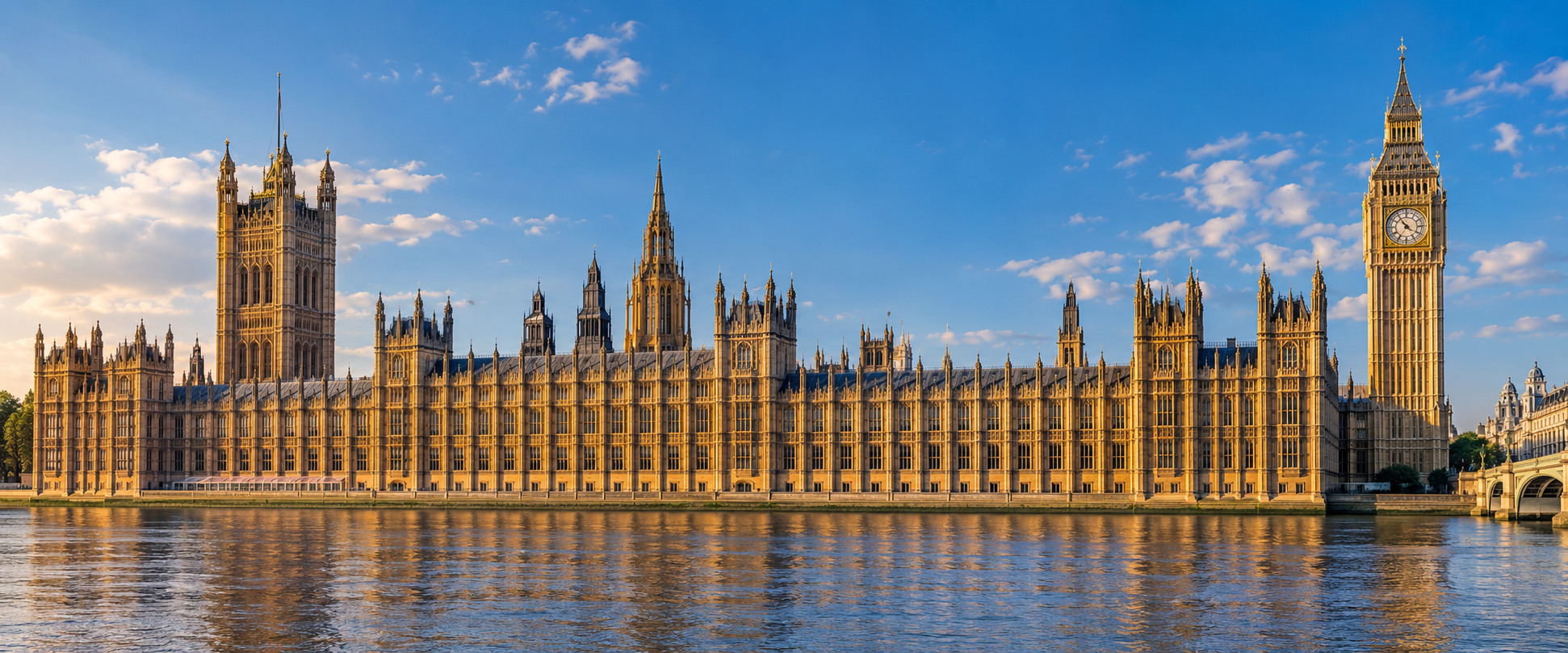 The Palace of Westminster and Elizabeth Tower beside the River Thames under a blue sky